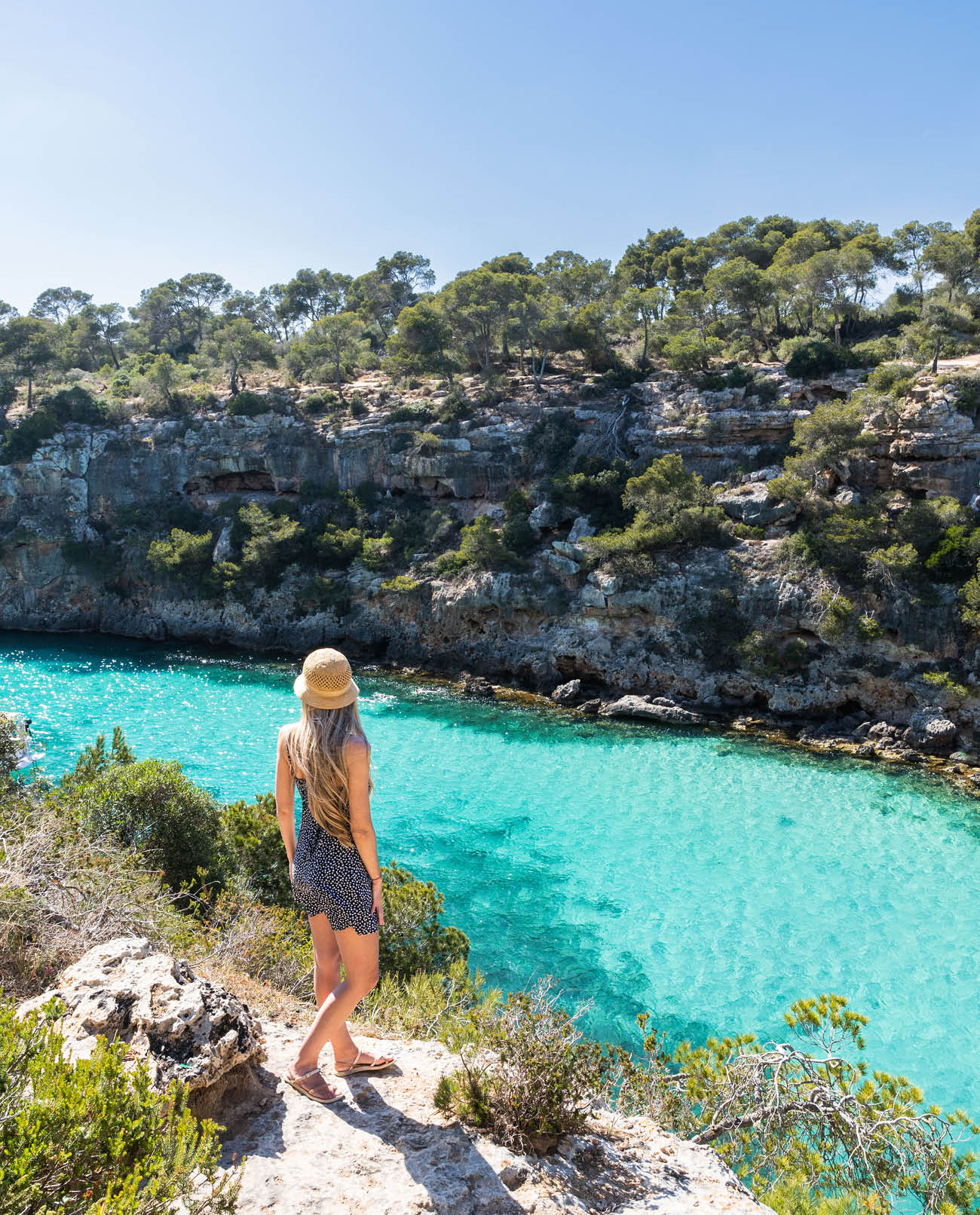 Rear view of woman with long blonde hair in cala pi, Mallorca, balearic islands. Turquoise water rounded by rocks