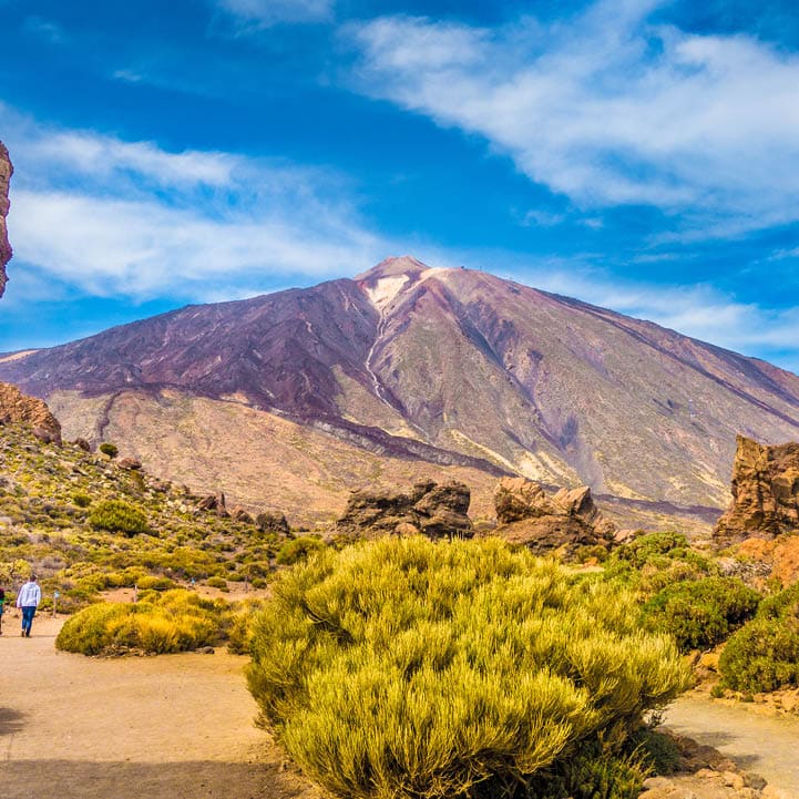 Panoramic view of unique Roque Cinchado unique rock formation with famous Pico del Teide mountain volcano summit in the background on a sunny day, Teide National Park, Tenerife, Canary Islands, Spain